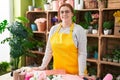 Young beautiful plus size woman florist smiling confident standing at flower shop Royalty Free Stock Photo