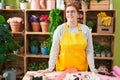 Young beautiful plus size woman florist smiling confident standing at flower shop Royalty Free Stock Photo