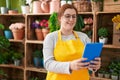 Young beautiful plus size woman florist smiling confident using touchpad at flower shop Royalty Free Stock Photo