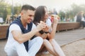 Young beautiful positive couple eating hambergers sitting on beach Royalty Free Stock Photo