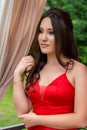 Radiant Beauty: Woman in Red Dress Posing in Restaurant Garden