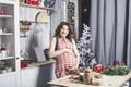 Young beautiful pregnant with at home in the kitchen smiling Royalty Free Stock Photo