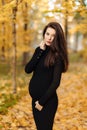 Young beautiful pregnant woman with dark hair in a black tight dress Royalty Free Stock Photo