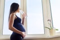 Young beautiful pregnant woman drinking water from bottle Royalty Free Stock Photo