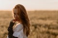 Young beautiful pregnant woman in white dress walking in the wheat orange field on a sunny summer day. Nature in the Royalty Free Stock Photo