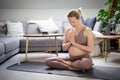 Young beautiful pregnant woman practising yoga at home in her living room. Motherhood, pregnancy, healthy lifestyle Royalty Free Stock Photo