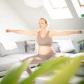 Young beautiful pregnant woman training pilates at home in her living room. Healthy lifestyle and active pregnancy and Royalty Free Stock Photo