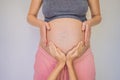 Young beautiful pregnant woman and eldest son. The cute boy put his hands on his mother& x27;s belly. Expecting a baby in Royalty Free Stock Photo