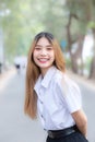 Young beautiful and pretty Asian female college student wearing uniform is standing smiling happily in university campus with Royalty Free Stock Photo