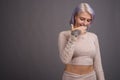 Young beautiful rebel woman with colorful hair against gray back