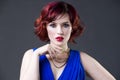 Young beautiful red-haired caucasian woman in blue dress posing in studio on gray background, professional makeup and hairstyle Royalty Free Stock Photo