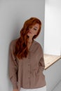 Young beautiful red-haired girl in a light shirt in the color of moko Royalty Free Stock Photo
