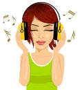 Young beautiful red haired woman enjoying the music with headphones