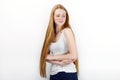 Young beautiful redhead beginner model woman in white t-shirt blue jeans practicing posing showing emotions standing against white Royalty Free Stock Photo