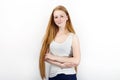 Young beautiful redhead beginner model woman in white t-shirt blue jeans practicing posing showing emotions standing against white Royalty Free Stock Photo