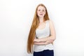 Young beautiful redhead beginner model woman in white t-shirt blue jeans practicing posing showing emotions standing against white Royalty Free Stock Photo