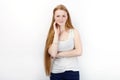 Young beautiful redhead beginner model woman in white t-shirt blue jeans practicing posing showing emotions standing against white Royalty Free Stock Photo