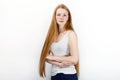 Young beautiful redhead beginner model woman in white t-shirt blue jeans practicing posing showing emotions standing against white Royalty Free Stock Photo