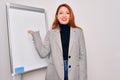 Young beautiful redhead businesswoman doing business presentation using magnetic board smiling cheerful presenting and pointing Royalty Free Stock Photo