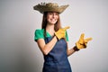 Young beautiful redhead farmer woman wearing apron and hat over white background smiling and looking at the camera pointing with Royalty Free Stock Photo