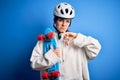 Young beautiful redhead skateboarder woman wearing safety helmet holding skate with angry face, negative sign showing dislike with Royalty Free Stock Photo