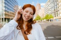 Young beautiful redhead smiling girl in headphones with closed eyes Royalty Free Stock Photo