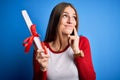 Young beautiful redhead student woman holding university diploma degree serious face thinking about question, very confused idea Royalty Free Stock Photo