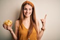 Young beautiful redhead woman holding bowl with potato chips over isolated white background surprised with an idea or question Royalty Free Stock Photo