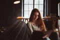 Young beautiful redhead woman relaxing at home in the autumn cozy evening and reading book Royalty Free Stock Photo