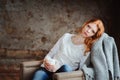 Young beautiful redhead woman relaxing at home in the autumn cozy evening and reading book Royalty Free Stock Photo