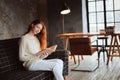 Young beautiful redhead woman relaxing at home in the autumn cozy evening and reading book Royalty Free Stock Photo