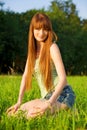 Young beautiful redhead woman sitting on grass Royalty Free Stock Photo