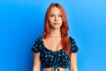 Young beautiful redhead woman wearing casual clothes over blue background relaxed with serious expression on face Royalty Free Stock Photo