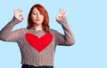 Young beautiful redhead woman wearing casual heart sweater relax and smiling with eyes closed doing meditation gesture with