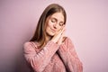 Young beautiful redhead woman wearing casual sweater over isolated pink background sleeping tired dreaming and posing with hands Royalty Free Stock Photo
