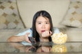 Young beautiful and relaxed Asian Chinese woman watching Korean drama on television on sad romantic movie eating popcorn at home Royalty Free Stock Photo