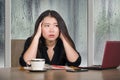 Young beautiful sad and depressed Asian Chinese business woman working exhausted and frustrated at office computer desk with rain Royalty Free Stock Photo