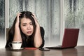 Young beautiful sad and depressed Asian Korean businesswoman working exhausted and frustrated at office computer desk with rain on Royalty Free Stock Photo