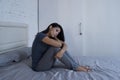 Beautiful sad and depressed Latin woman sitting on bed at home f Royalty Free Stock Photo