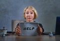 Young beautiful sad and stressed business woman working at office computer desk holding notepad asking for help feeling desperate Royalty Free Stock Photo