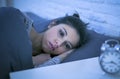 Young beautiful sad and worried latin woman suffering insomnia and sleeping disorder problem unable to sleep late at night lying o Royalty Free Stock Photo