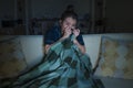 Young beautiful scared and frightened Asian Chinese woman watching horror scary movie or thriller eating popcorn in fear face Royalty Free Stock Photo