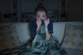 Young beautiful scared and frightened Asian Korean woman watching horror scary movie or thriller eating popcorn in fear face Royalty Free Stock Photo