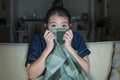 Young beautiful scared and frightened Asian Korean woman watching horror scary movie or thriller eating popcorn in fear face Royalty Free Stock Photo