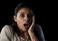 Young beautiful scared Spanish woman in shock and surprise face expression isolated on black Royalty Free Stock Photo