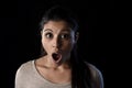 Young beautiful scared Spanish woman in shock and surprise face expression isolated on black Royalty Free Stock Photo