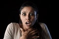 Young beautiful scared Spanish woman in shock and surprise face expression isolated on black Royalty Free Stock Photo