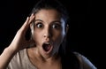 Young beautiful scared Spanish woman in shock and surprise face expression isolated on black Royalty Free Stock Photo