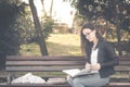 Young beautiful school or college girl with eye glasses sitting on the bench in the park reading the books and study for exam, kno Royalty Free Stock Photo