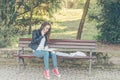 Young beautiful school or college girl with glasses sitting on the bench in the park reading the books and study for exam Royalty Free Stock Photo